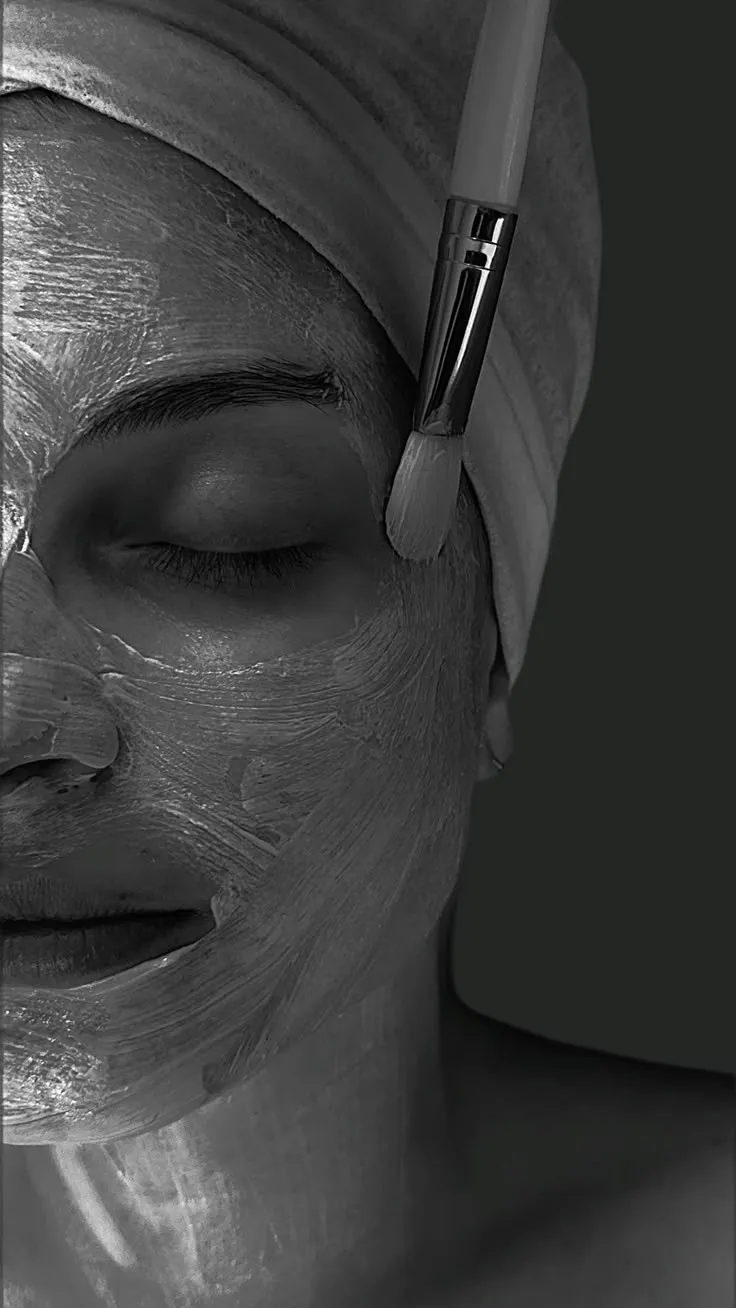 Rosto com máscara facial sendo aplicada com pincel