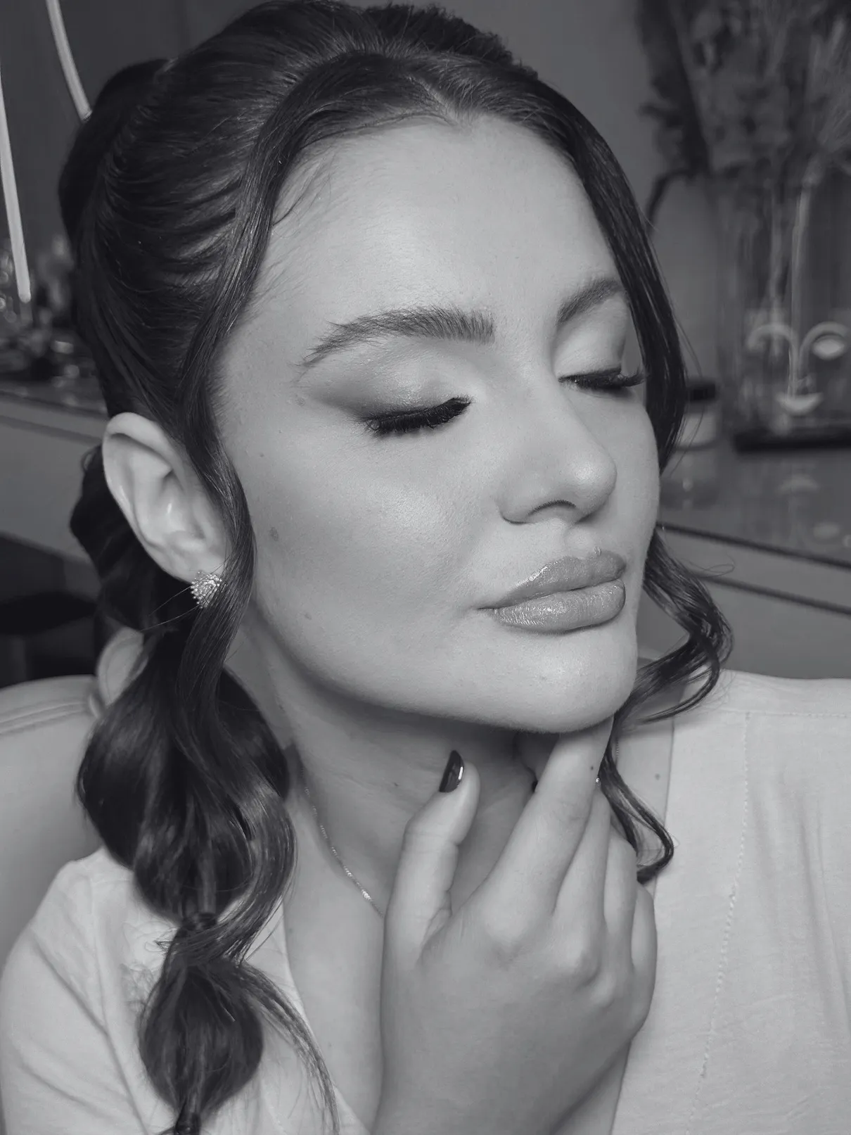 Cliente de olhos fechados exibindo maquiagem e penteado semipreso