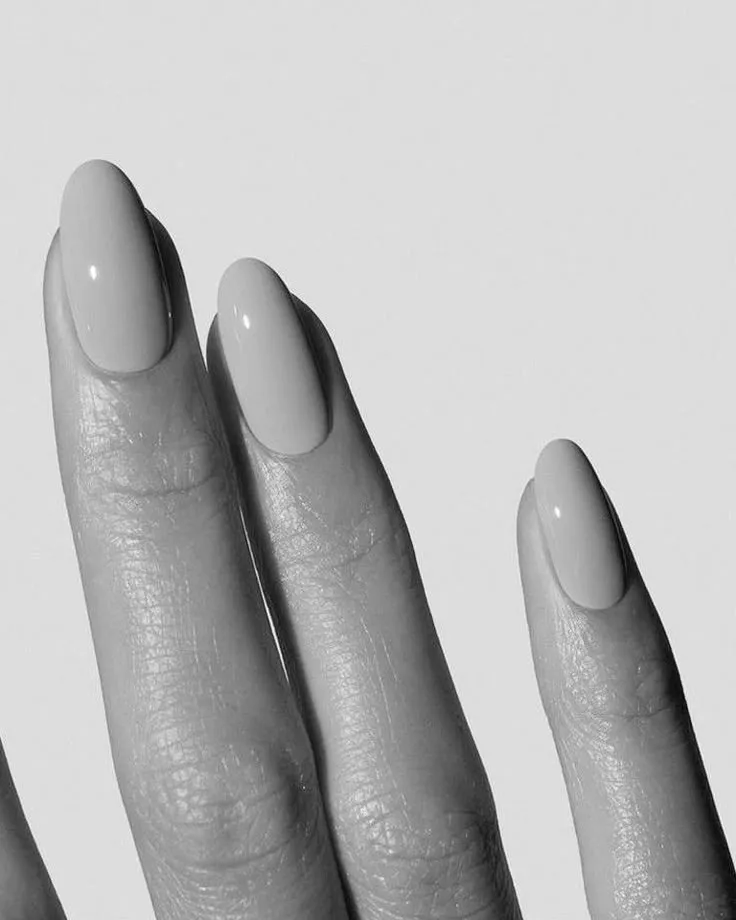 Dedos com unhas amendoadas esmaltadas em preto e branco